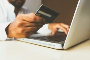 personne utilisant un ordinateur portable tenant une carte