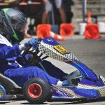 Un pilote en kart Mach1 conduit sur circuit avec cônes orange