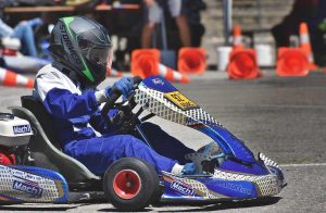 Un pilote en kart Mach1 conduit sur circuit avec cônes orange