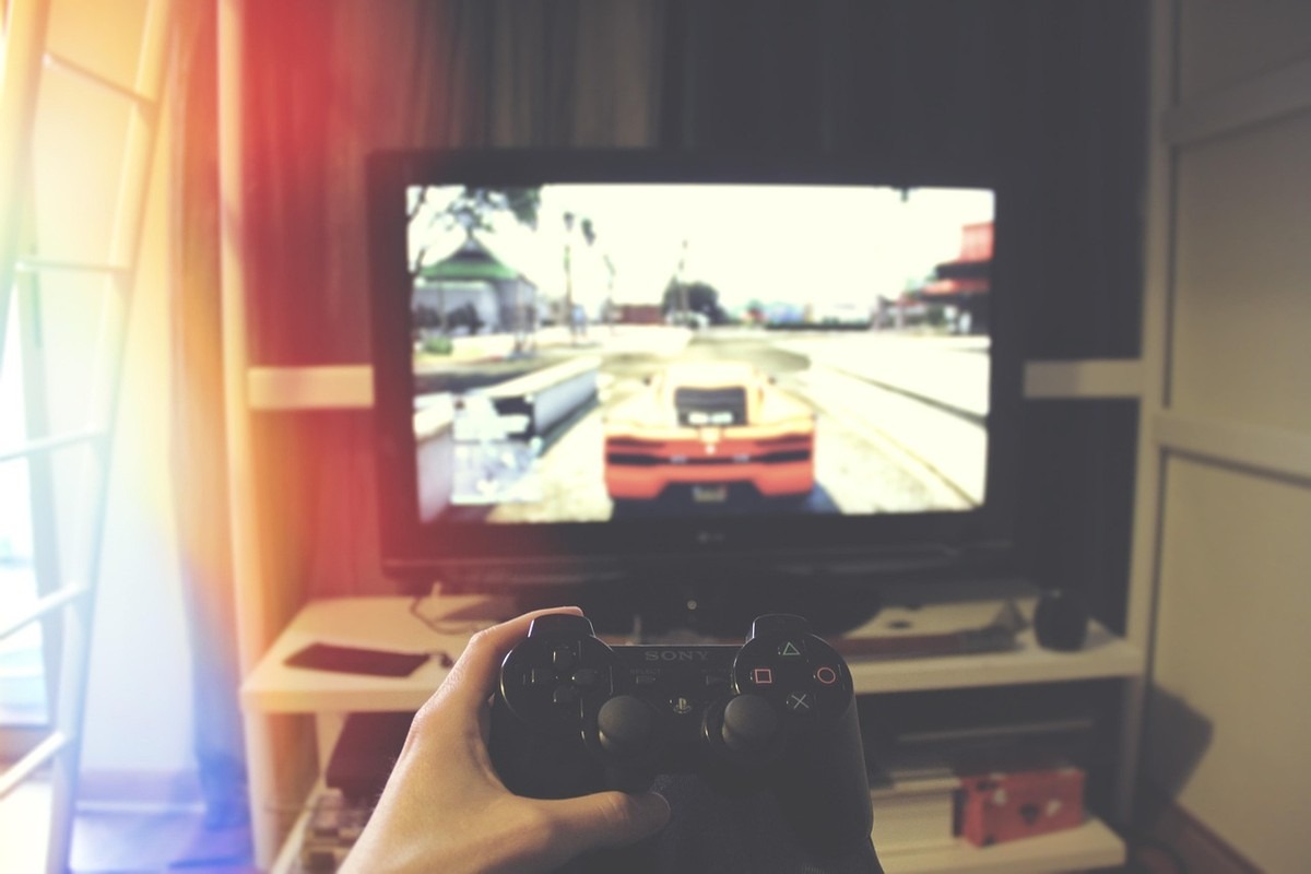 Jeu vidéo sur écran, main avec manette, salon coloré Jeu vidéo sur écran, main avec manette, salon coloré