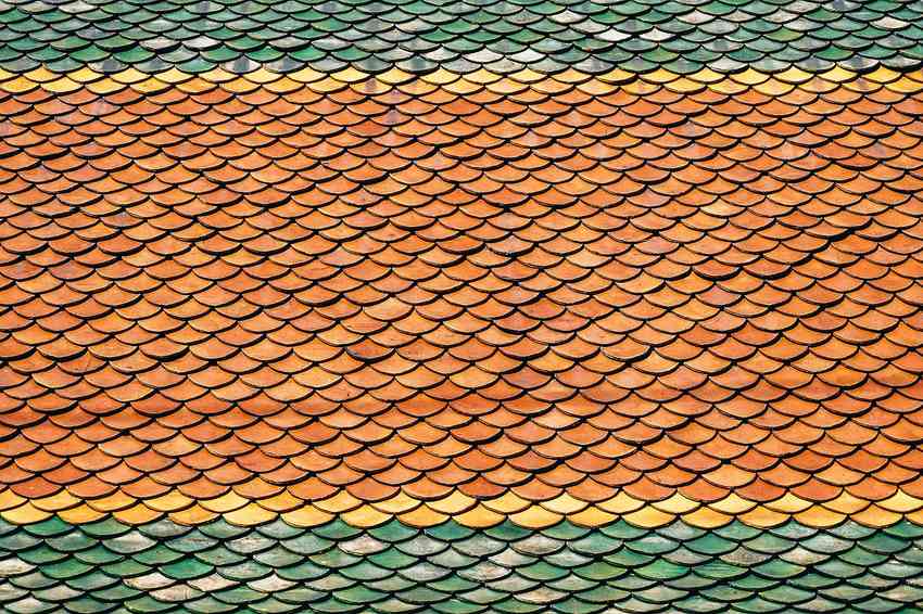 Tuiles imbriquées formant un motif ondulé aux teintes vertes jaunes et orangées